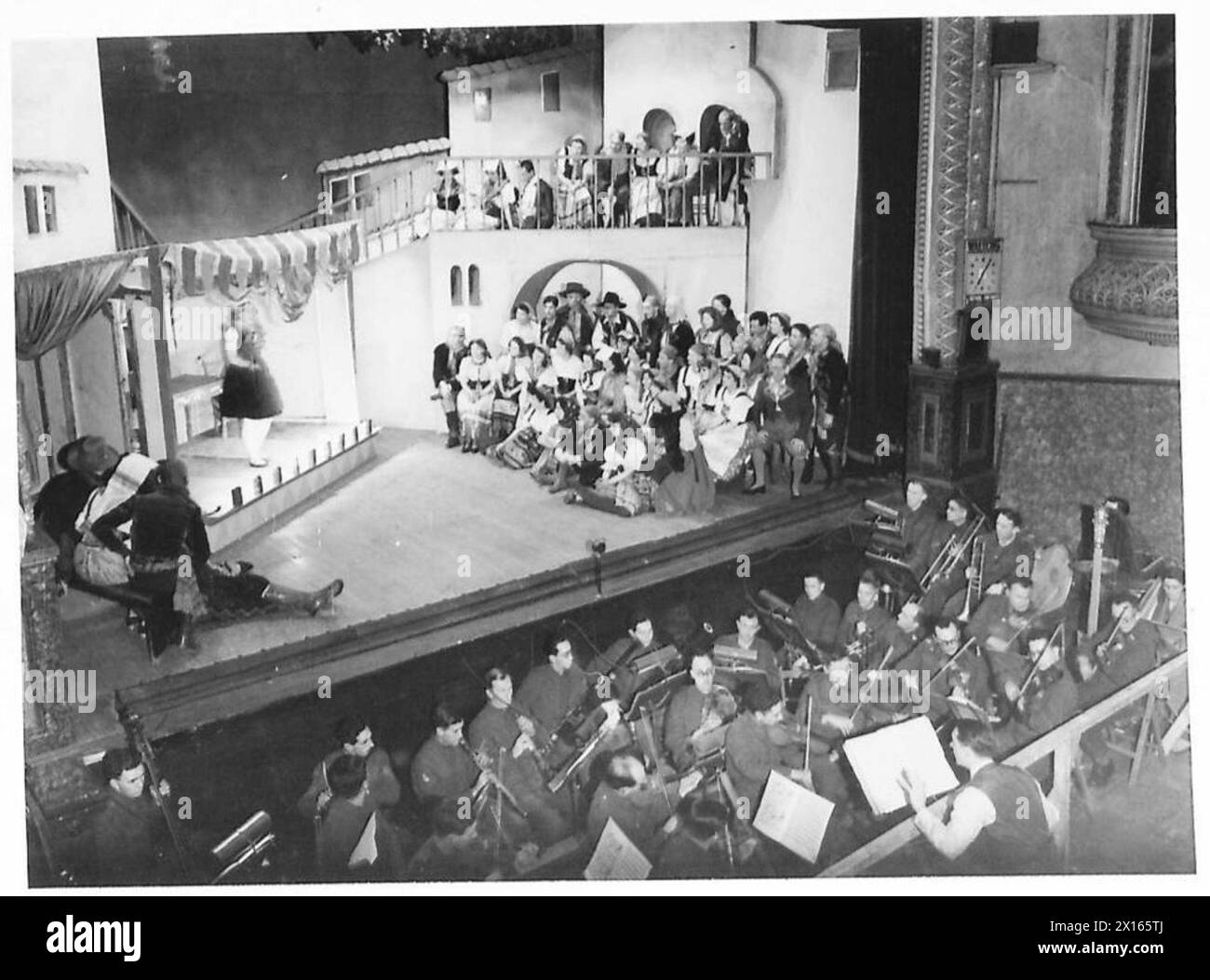 THE ARMY PRODUCES AN OPERA - The final act of 'I Pagliacci' produced in the Western Command by the Army. They have also formed a symphony orchestra, part of which is seen playing in the foreground The scenery was done by a corporal in the Pioneer Corps Corporal Ernest Stern, who is famous for his designs for Max Reinhardt and Erik Charell British Army Stock Photo