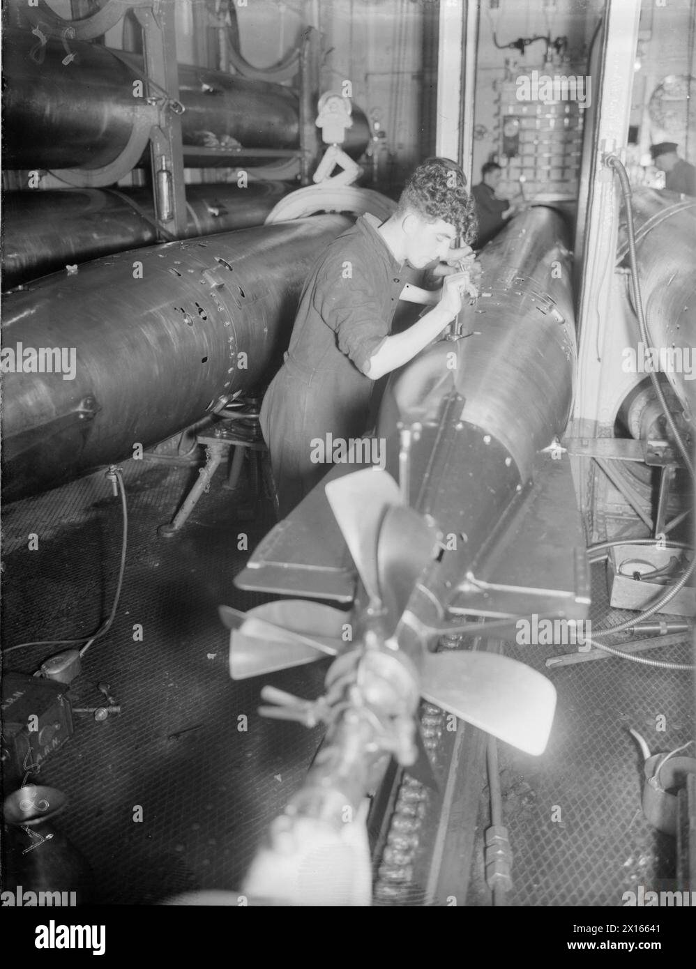 IN THE TORPEDO ROOM OF A WARSHIP. SEPTEMBER 1940, ON BOARD HMS RODNEY. - Torpedoes being listed Stock Photo