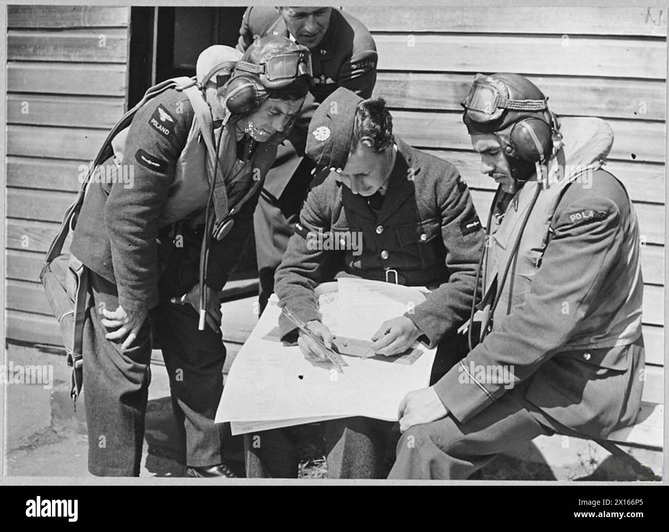 THE POLISH AIR FORCE IN BRITAIN, 1940-1947 - RAF instructor of No. 18 Operational Training Unit analysing the results of a bombing exercise over the Cardigan Bay with Polish trainee airmen (probably future members of No. 301 Bomber Squadron) at No. 9 Bombing and Gunnery School at RAF Penrhos, 14 July 1940. The exercise was carried on Fairey Battle Mk. I light bombers.No. 18 OTU was formed from the Polish Training Unit in No. 6 Group, Bomber Command, in June 1940 to train light bomber crews for Polish operational squadrons Polish Air Force, Polish Air Force, 301 'Land of Pomerania' Bomber Squad Stock Photo
