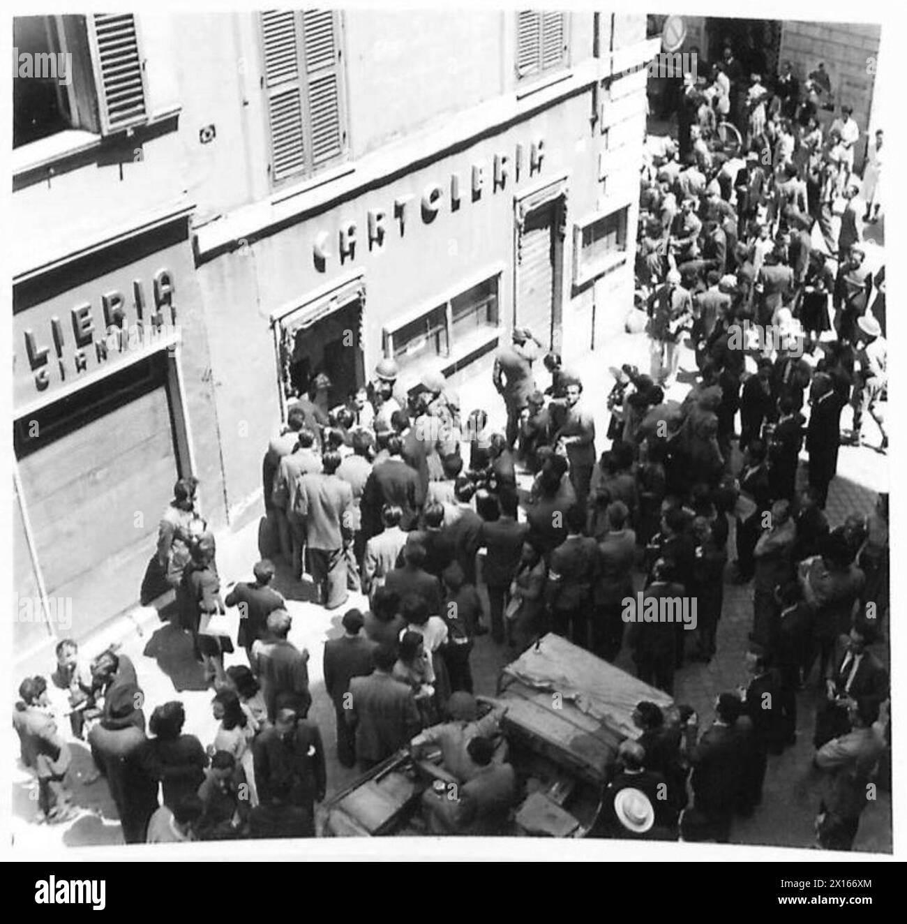 THE BRITISH ARMY IN NORTH AFRICA, SICILY, ITALY, THE BALKANS AND AUSTRIA 1942-1946 - A German-owned stationers was broken open and looted by a mob, until an armed party from the P.L.I. Italian Liberal Party arrived to stop the looting British Army Stock Photo