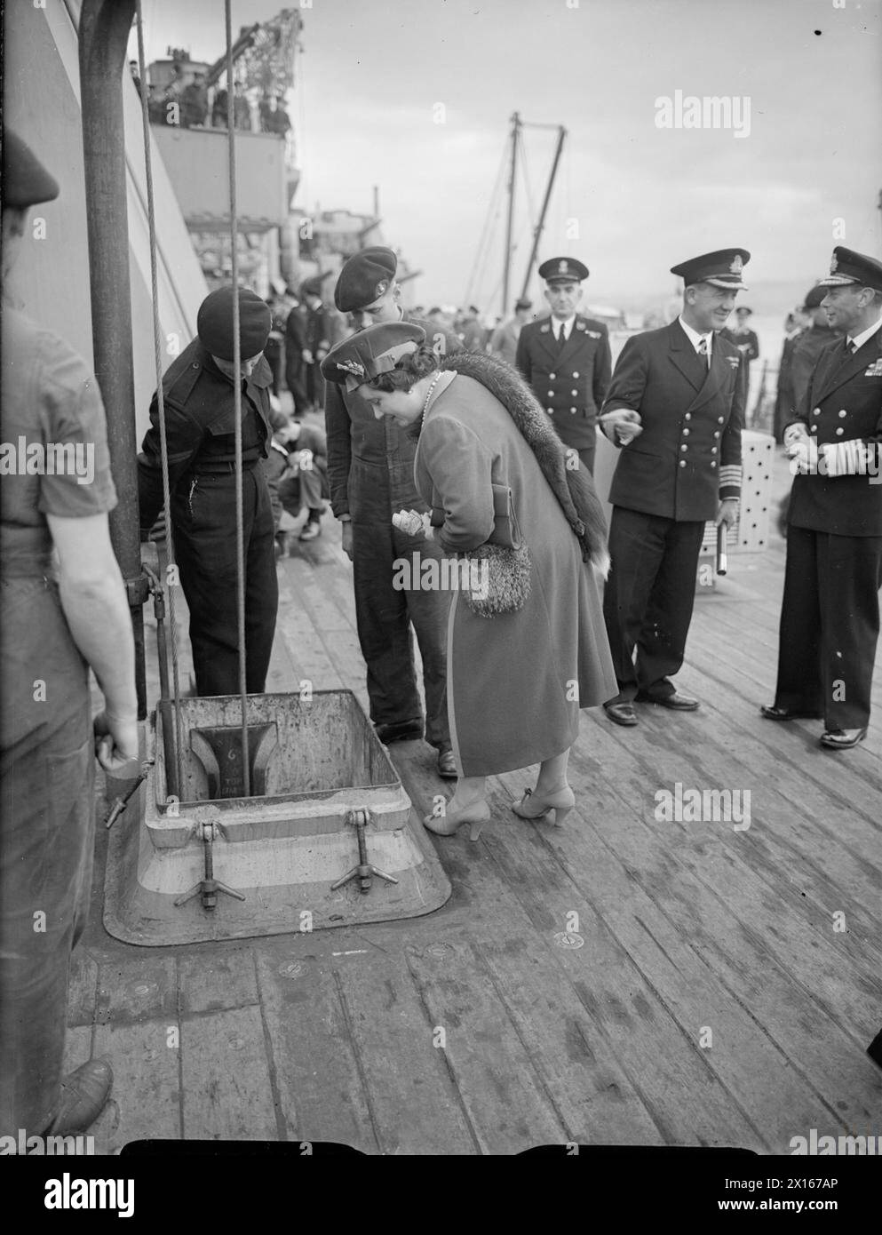 ROYAL VISIT TO HMS KING GEORGE V. 29 OCTOBER 1944, GREENOCK. THE KING AND QUEEN ACCOMPANIED BY PRINCESS ELIZABETH AND PRINCESS MARGARET PAID A FAREWELL VISIT TO THE BATTLESHIP HMS KING GEORGE V BEFORE SHE LEFT TO JOIN BRITAIN'S EAST INDIES FLEET. - The Queen watching ammunition being lowered to the ammunition locker Stock Photo