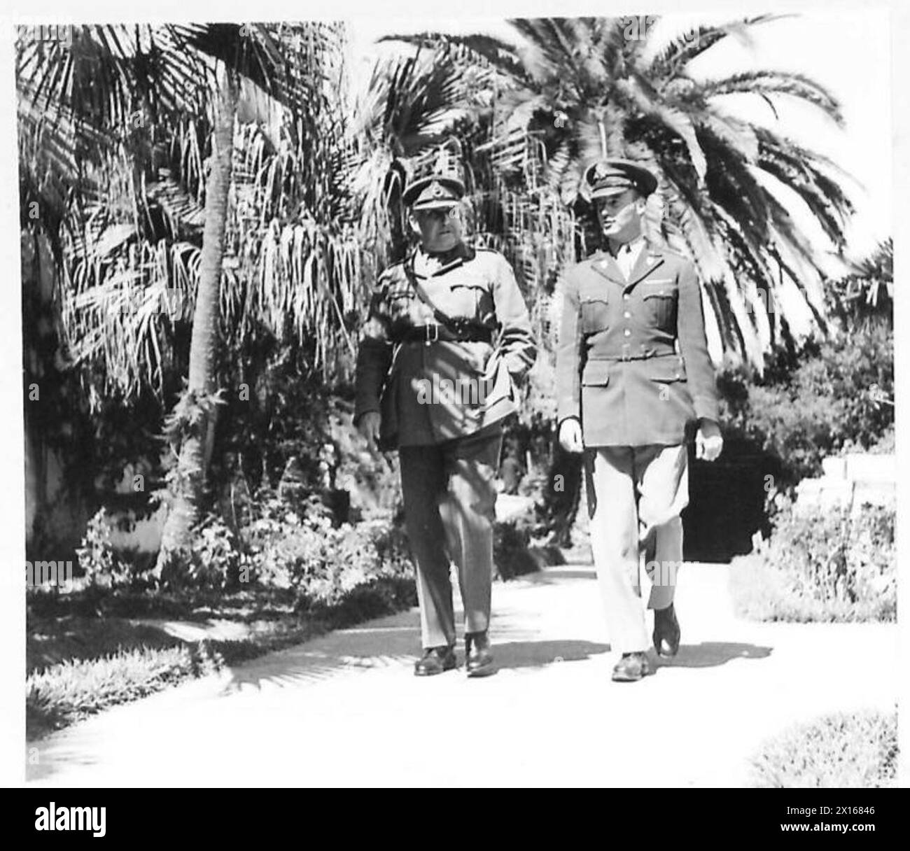 NEW PHOTOGRAPHS OF THE COMMANDER-IN-CHIEF MEDITERRANEAN THEATRE. TAKEN IN THE GROUNDS OF HIS VILLA AT ALGIERS - General Sir Henry Maitland Wilson walking in the garden of his villa, with his American A.D.C. Major John L. Shutz British Army Stock Photo