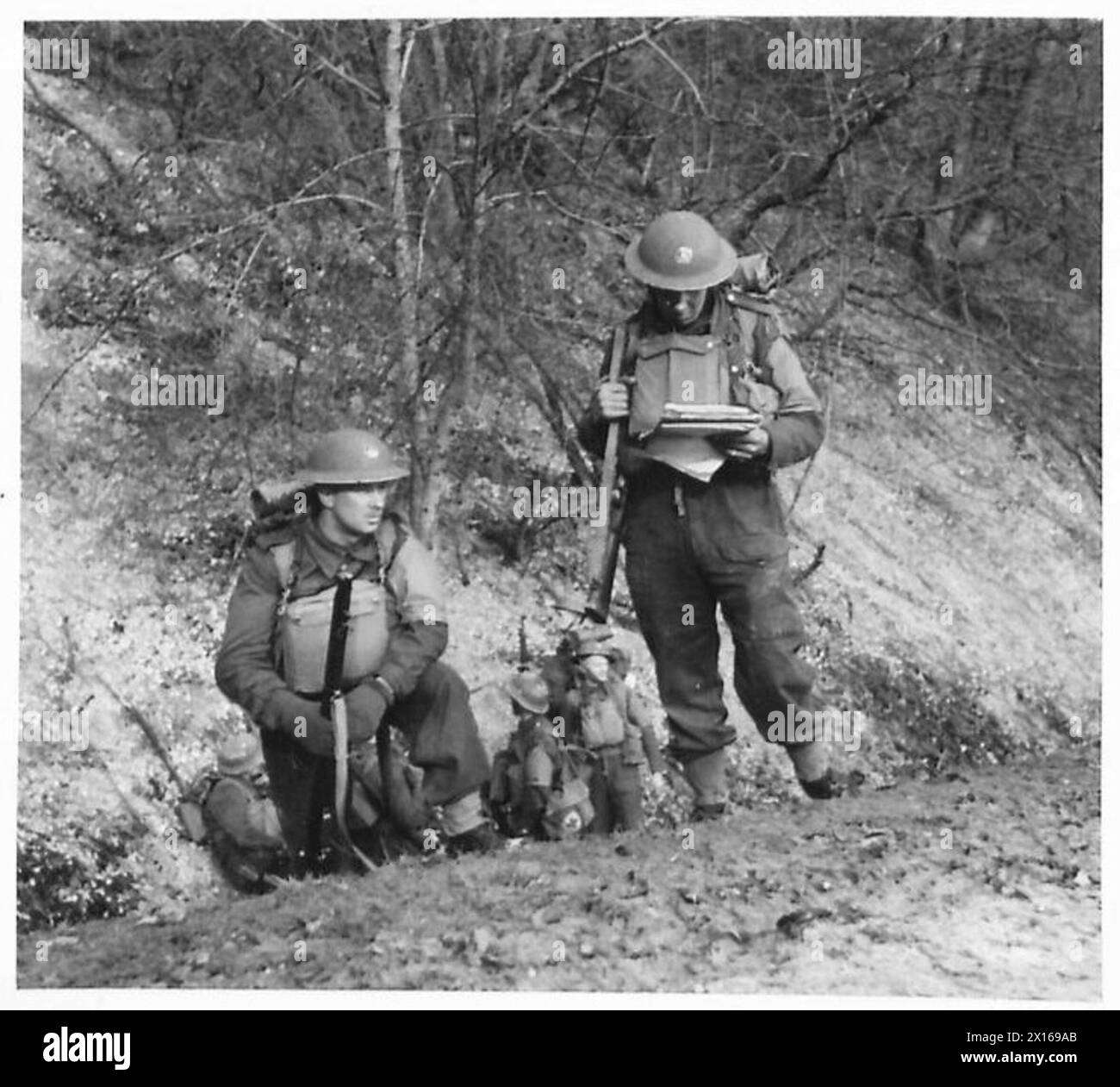 ROUNDING UP PARACHUTE TROOPS - A sergeant of the South Wales Borders consults his map whilst his section are resting by the side of a sunken road on the side of the South Downs at Chanctonbury Hill, Sussex, 4th Corps area British Army Stock Photo