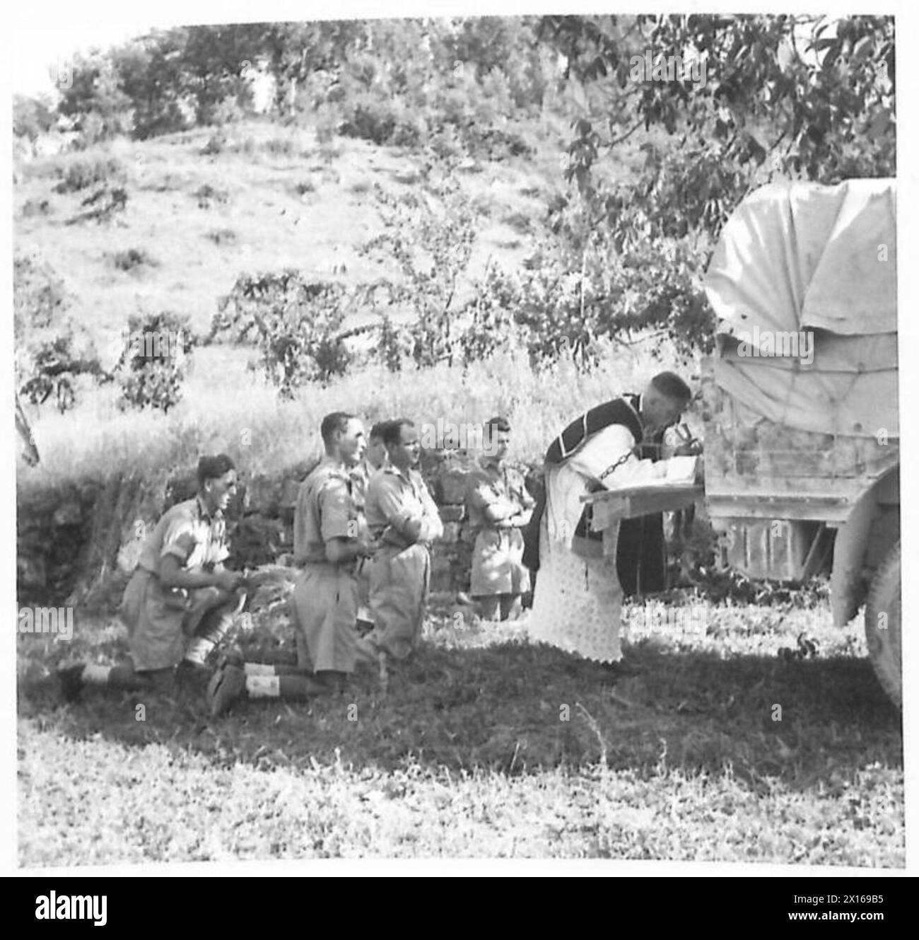 EIGHTH ARMY : VARIOUS - Rev. B.J. Costello, South African Catholic chaplain, giving a Requiem Mass for officers and men of the South African Division killed during Cassino. The small congregation is the Roman Catholic personnel of a Bde. H.Q British Army Stock Photo