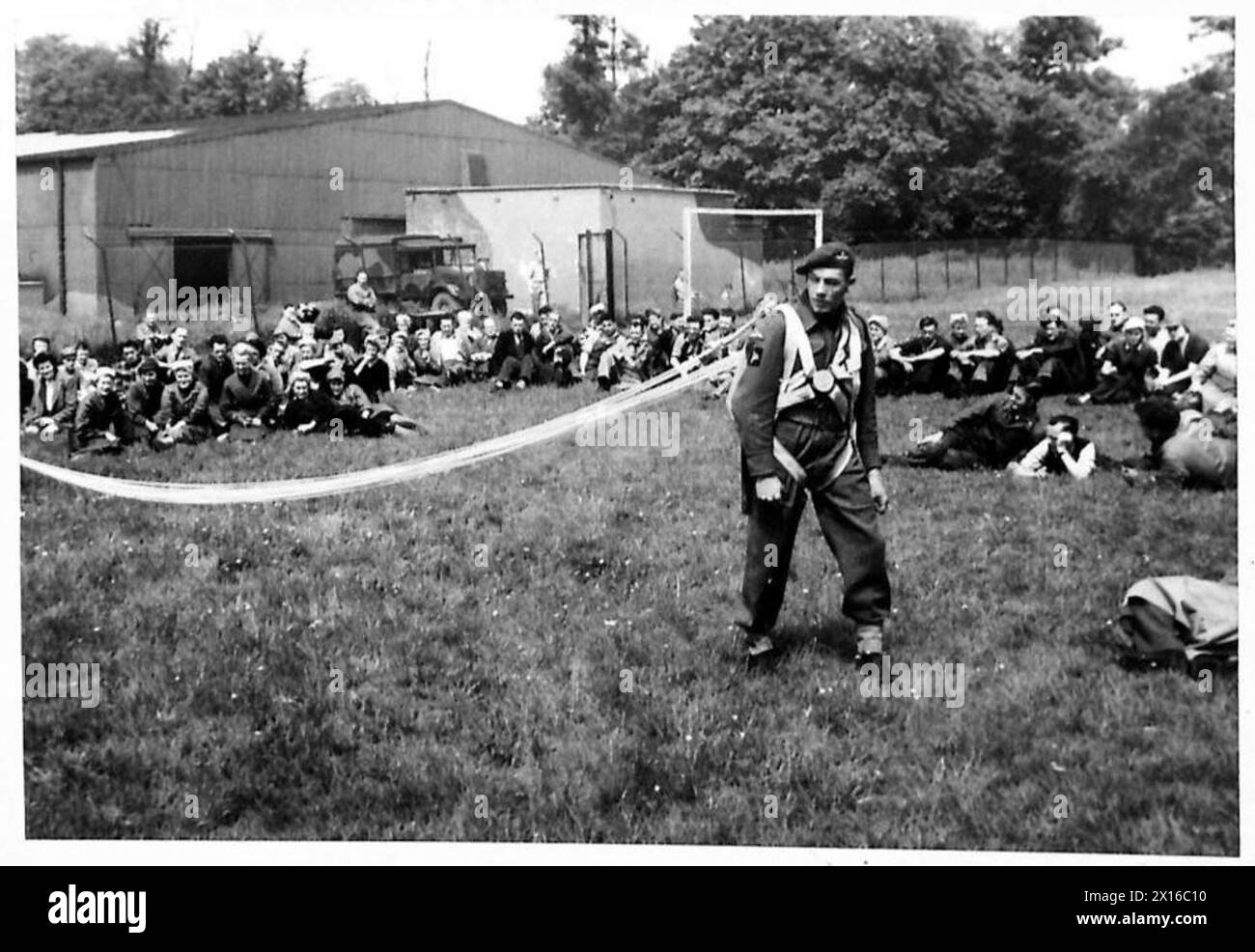 PARATROOPS DEMONSTRATE TO FACTORY WORKERS - Private Williamson, W. of Boldon Colliery, Co.Durham, demonstrates how the paratroop harness is fitted and the parachute opens Stock Photo