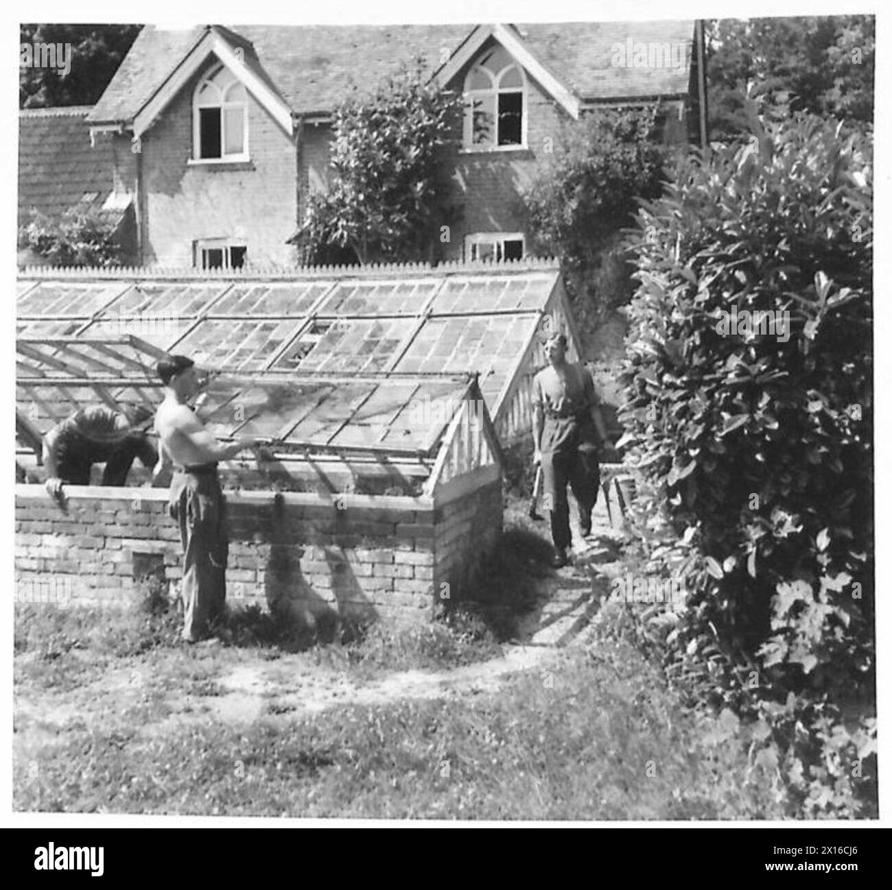 SOLDIER GARDENERS Soldiers at work in the garden. The cottage in