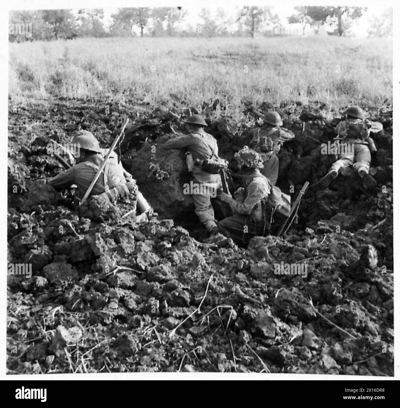 British Eighth Army infantrymen advance using cover while engaging enemy troops in wooded areas during the breakthrough of the Hitler Line. Stock Photo