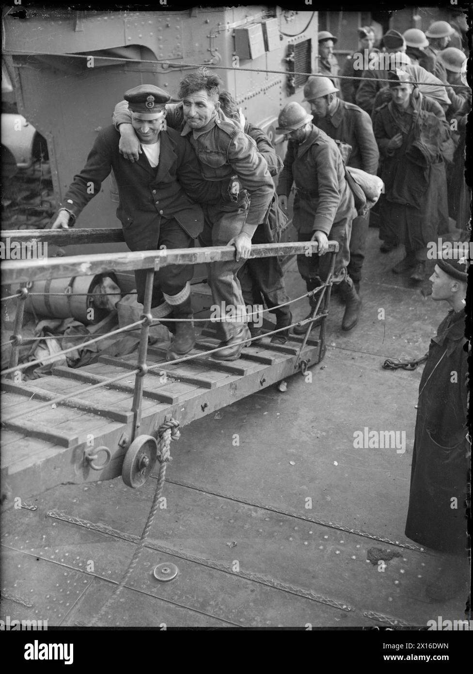 THE BRITISH ARMY IN THE UK: EVACUATION FROM DUNKIRK, MAY-JUNE 1940 - A merchant sailor assists a wounded british soldier up the gangplank from a destroyer, Dover, 31 May 1940 Stock Photo