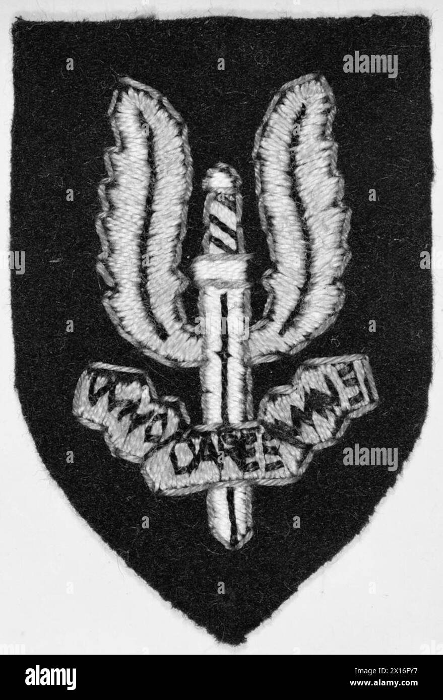 THE SPECIAL AIR SERVICE (SAS) - The cloth cap badge of the SAS. In an effort to consolidate the identity of his new unit, Colonel Stirling privately arranged for this insignia to be made up by a Cairo tailor. The cap badge was originally designed as a flaming 'sword of Damocles' but ended up as a winged dagger. The motto 'Who Dares Wins' summed up Stirling's original SAS concept British Army, Special Air Service Stock Photo