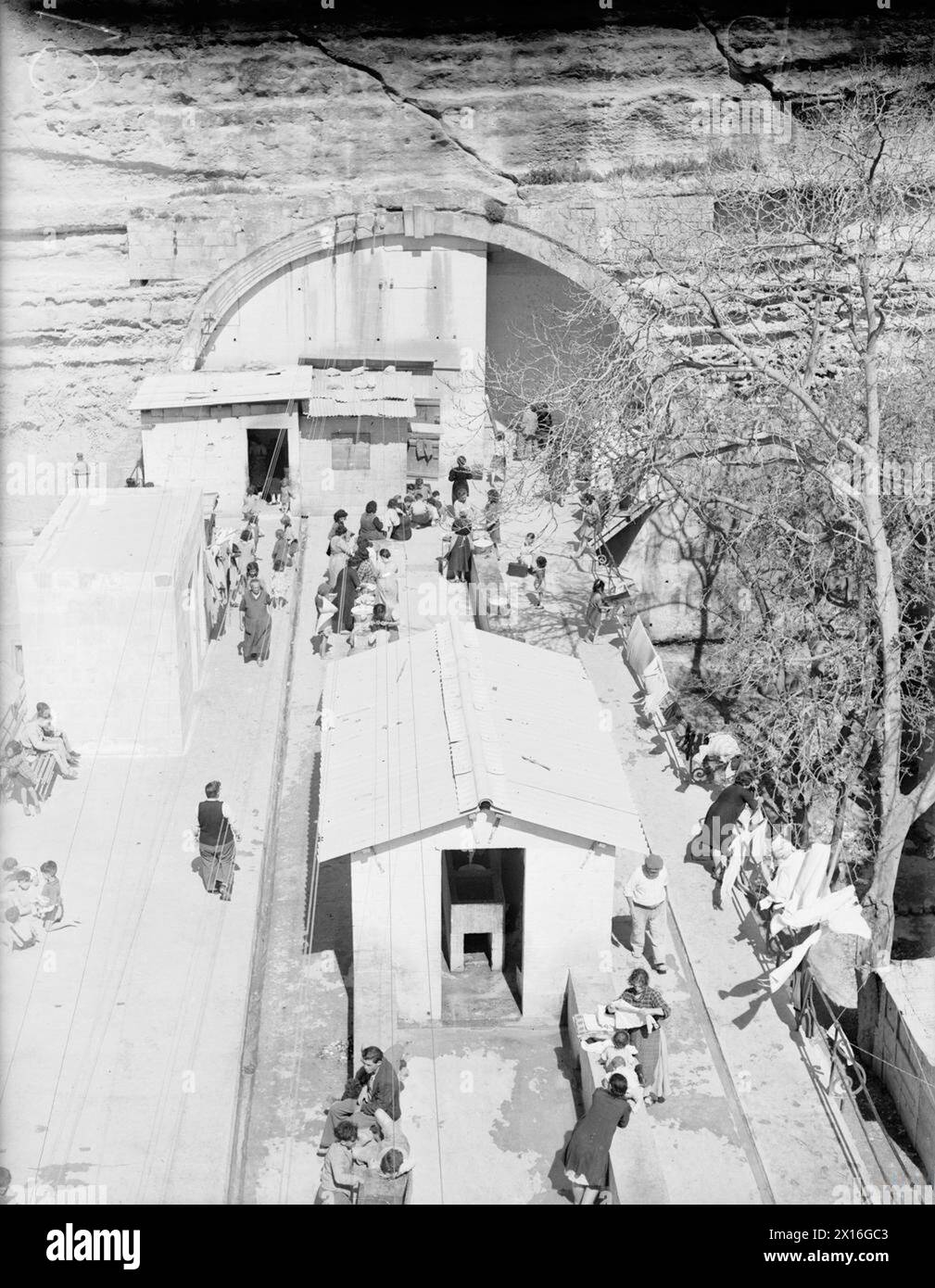 MALTA SUFFERS BIGGEST RAID OF THE WAR SO FAR. 7 APRIL 1942, MALTA. DAMAGE TO CIVILIAN PROPERTY AS A RESULT OF THE MASSIVE AXIS RAID. - An old railway tunnel makes a good air raid shelter. Here the islanders are seen taking the opportunity of a lull in the 'blitz' to get some fresh air and exercise Stock Photo
