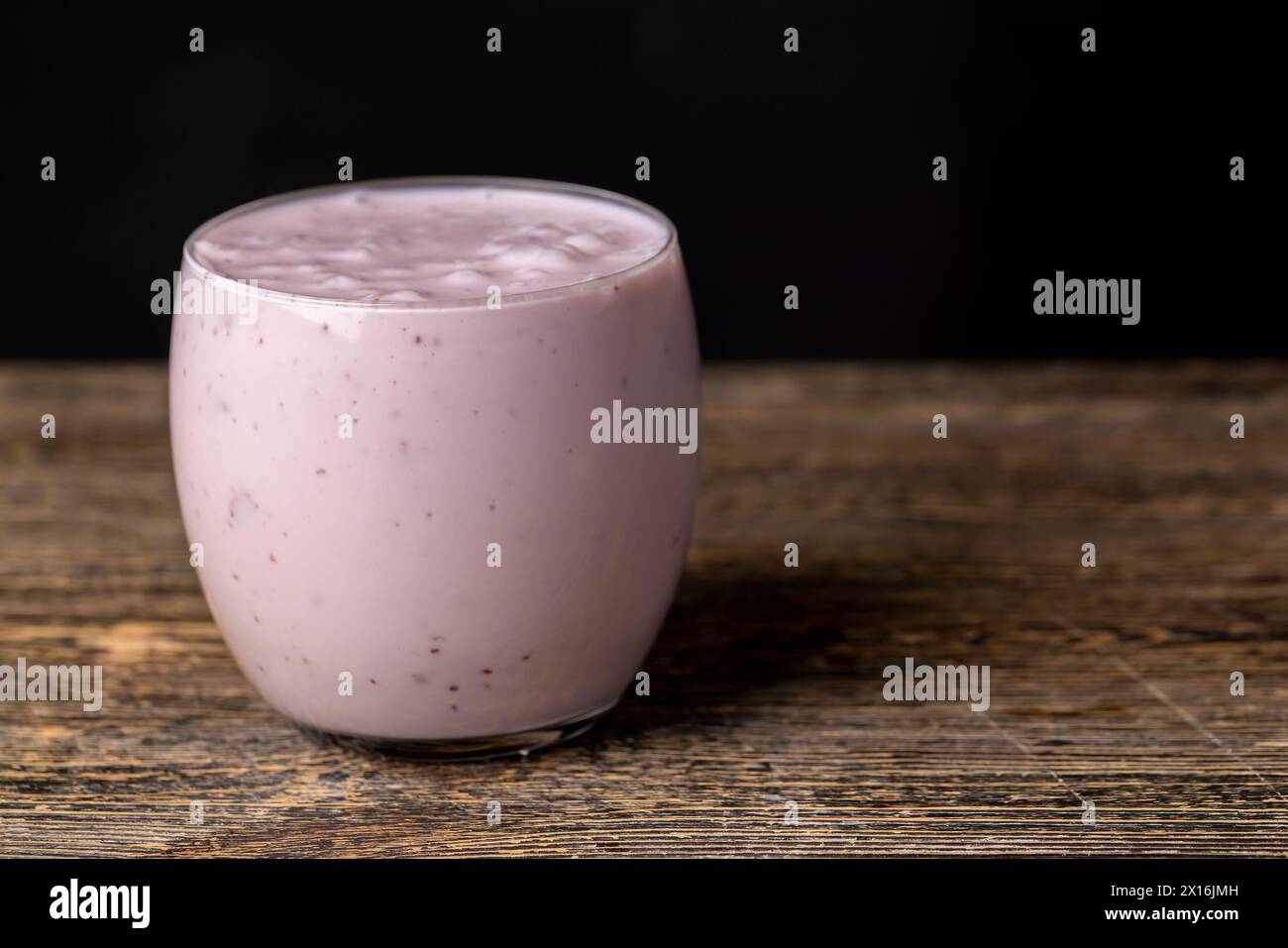 pink fermented milk drink with berry flavor, pieces of berries and berry flavor of milk yogurt Stock Photo