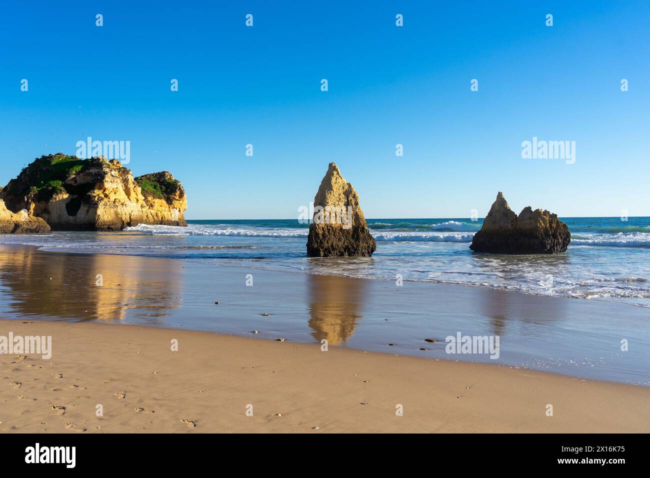 3 Irmaos beach with an islet seen through a rock in the town of Alvor in the Algarve region Stock Photo