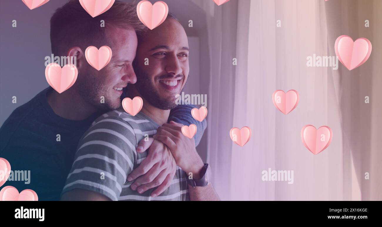 Image of heart icons over diverse gay couple embracing Stock Photo