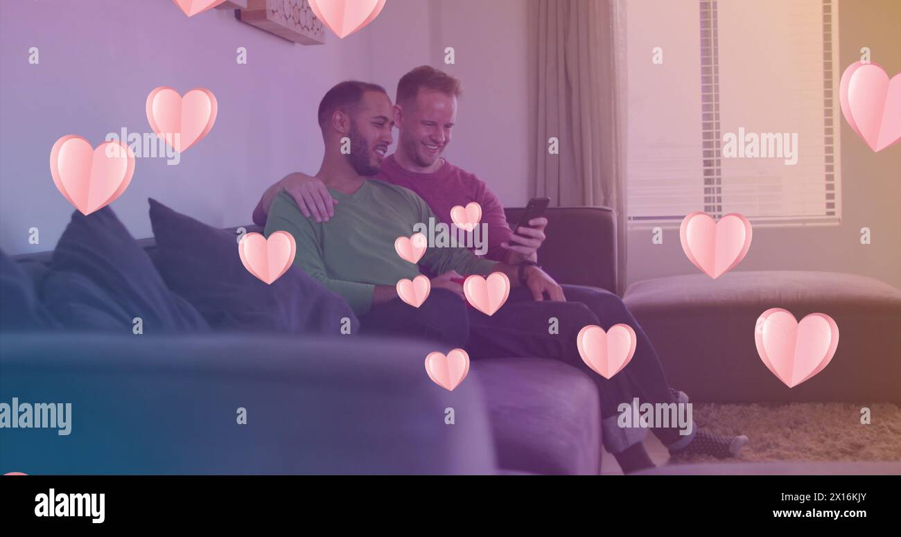 Image of heart icons over happy diverse gay couple embracing Stock Photo
