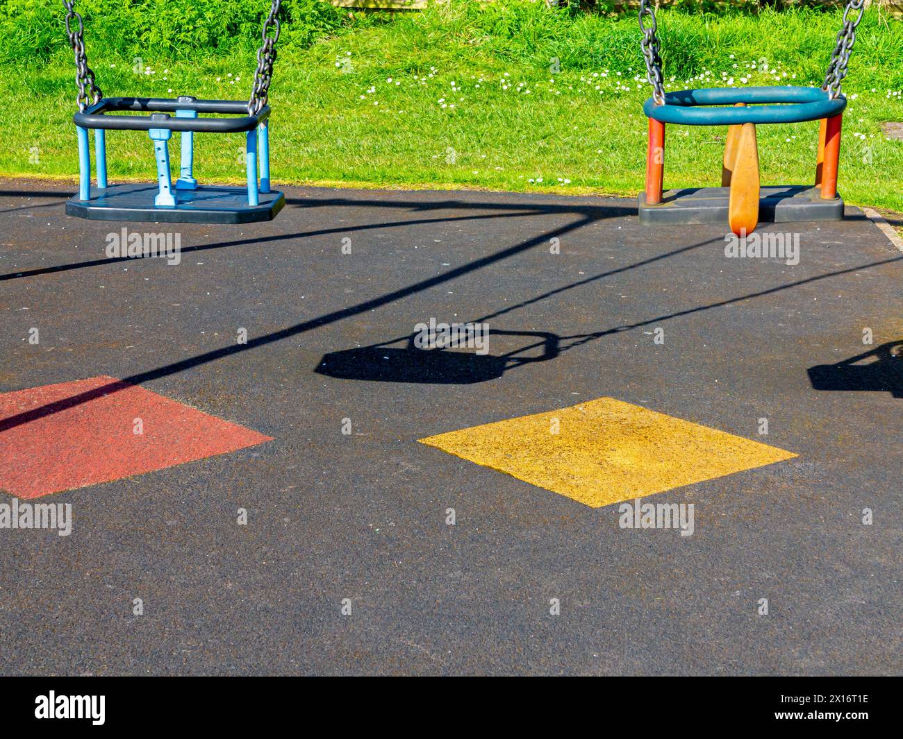 Close up view of swings for young children in a playground with safety ...