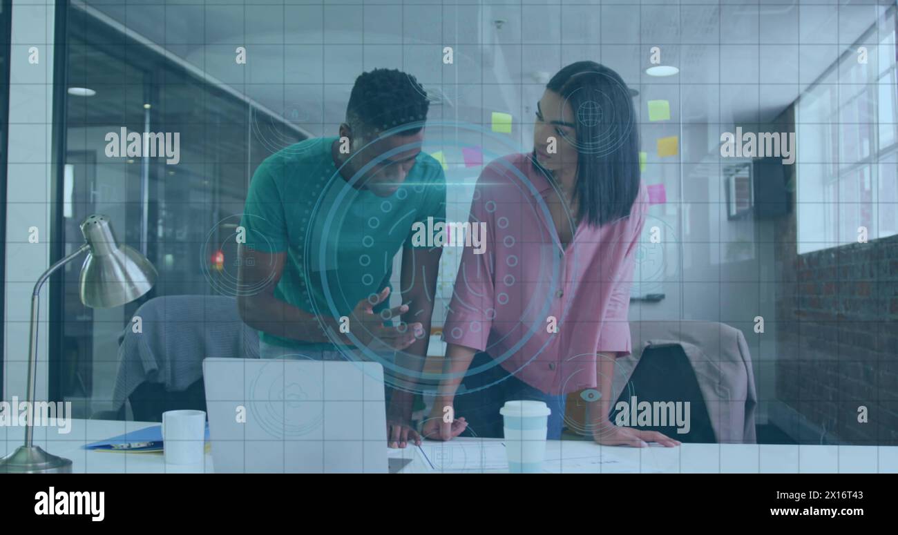 Image of fingerprint scanner over diverse male and female colleagues discussing over a plan Stock Photo