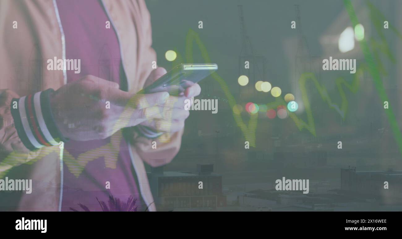 Mid section of man using smartphone against spots of light Stock Photo