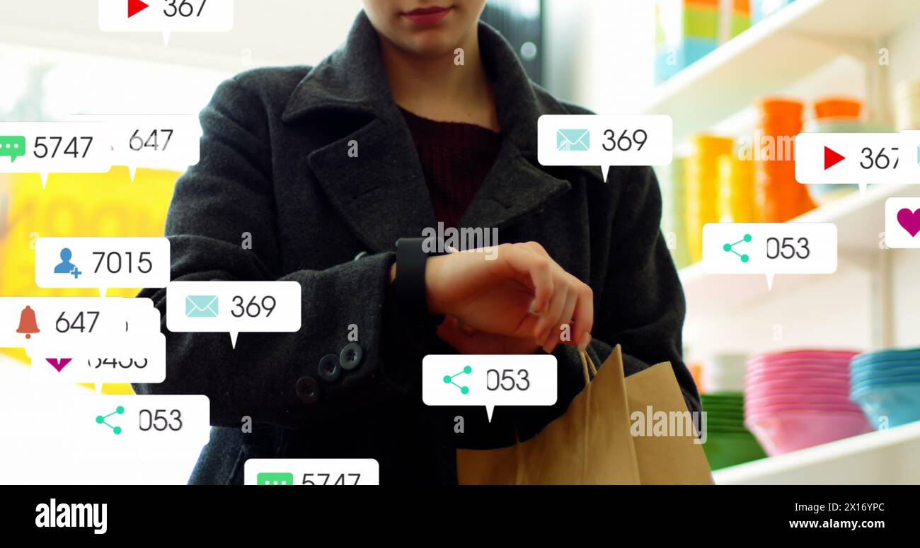 Image of notification bars over caucasian woman scrolling on smartwatch in grocery store Stock Photo