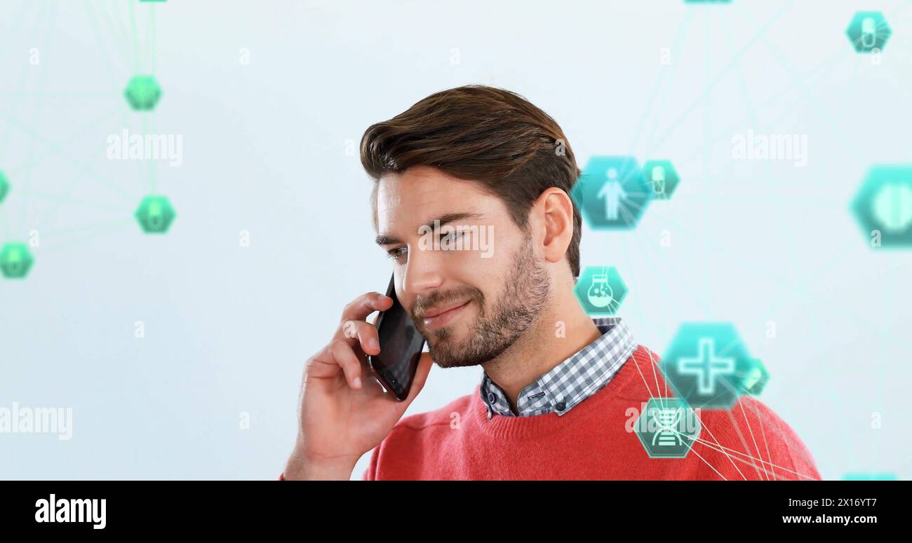 Image of connected icons globe over caucasian man standing and talking on smartphone Stock Photo