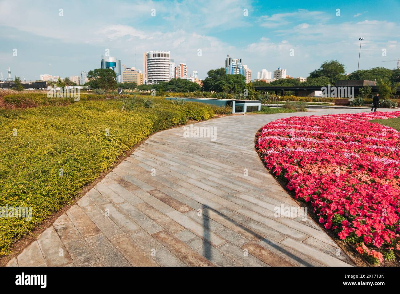 a walking path and flower bed in Al Shaheed Park, Kuwait City Stock Photo