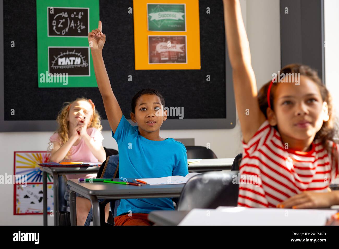 Teenagers in classroom raising hands hi-res stock photography and ...