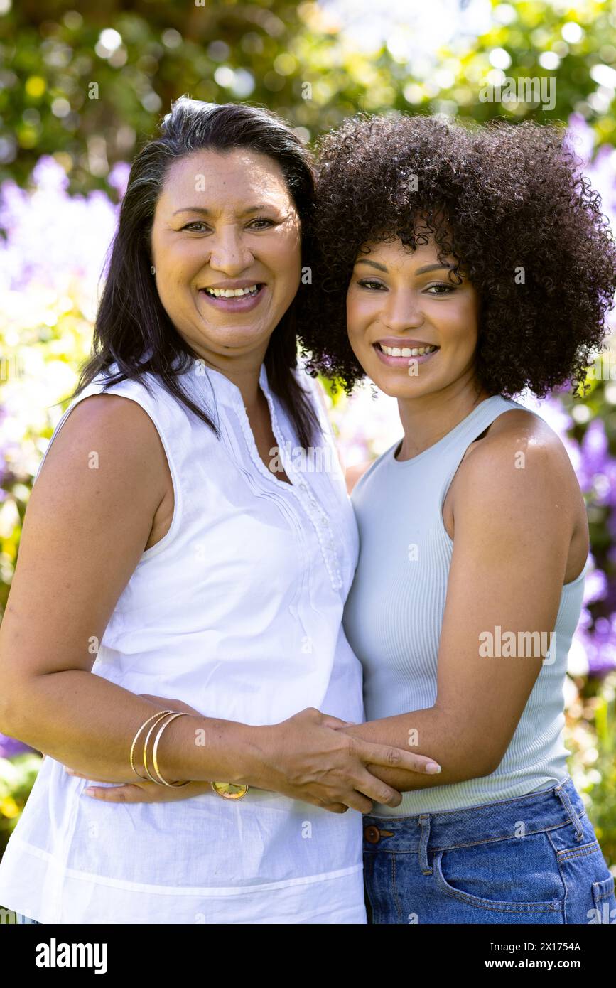 Mother and Daughter, biracial mother and daughter, embracing, standing in garden at home Stock Photo