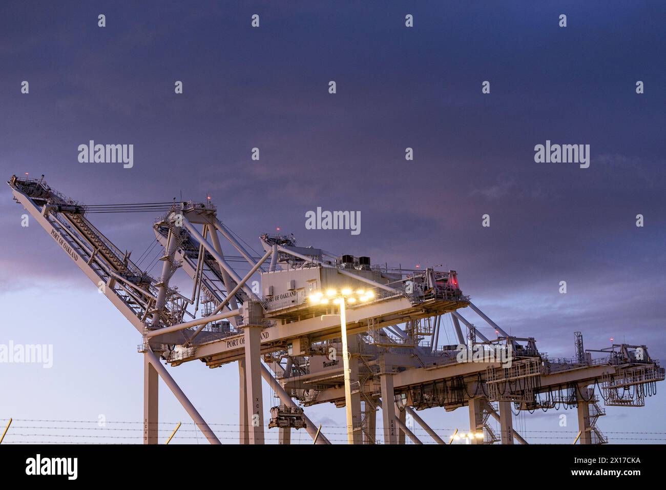 Cranes at sunset await shipping containers Stock Photo - Alamy