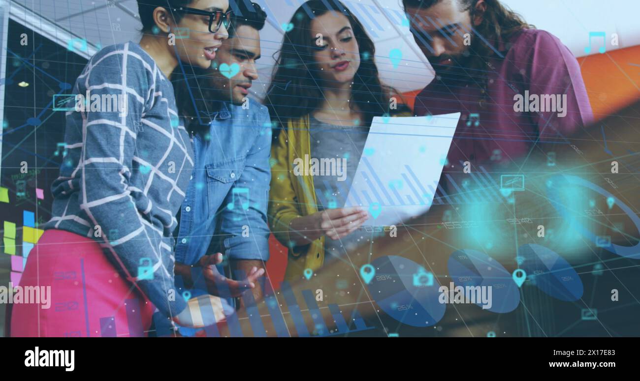 Image of network of digital icons over group of diverse colleagues discussing over a document Stock Photo