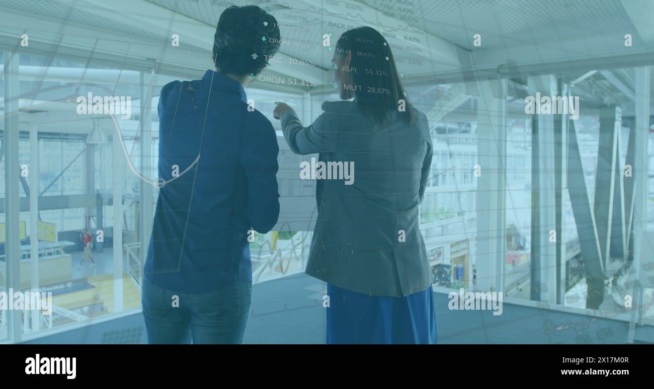 Image of data processing over diverse businessman and businesswoman Stock Photo