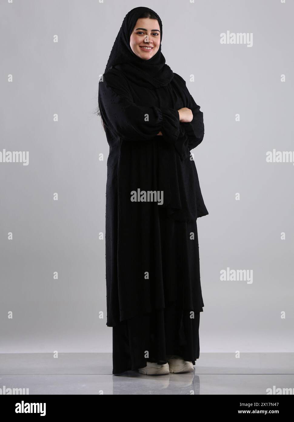 saudi arabian woman lady standing wearing hijaab looking infront side view smiling Stock Photo