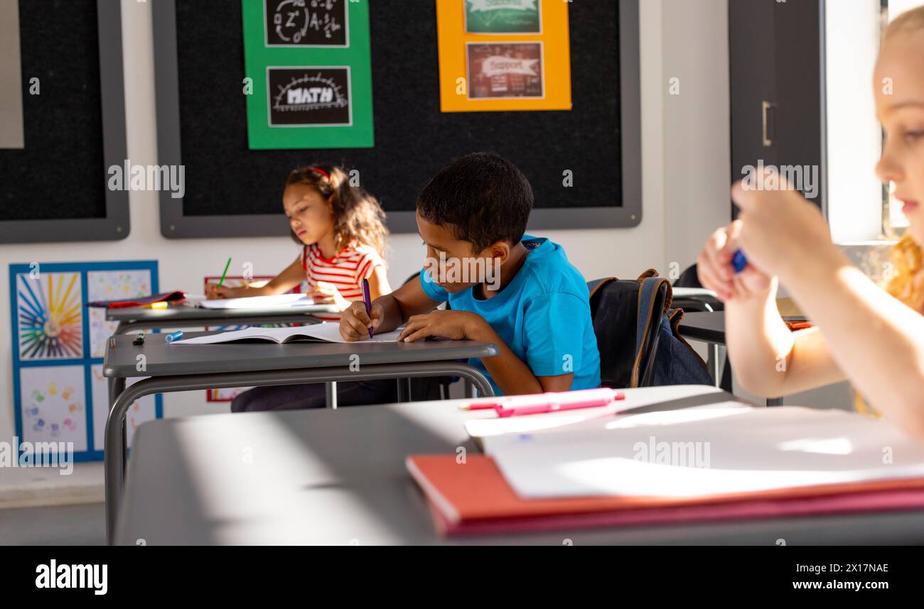 In school, in the classroom, a diverse group of young students focusing on their work Stock Photo
