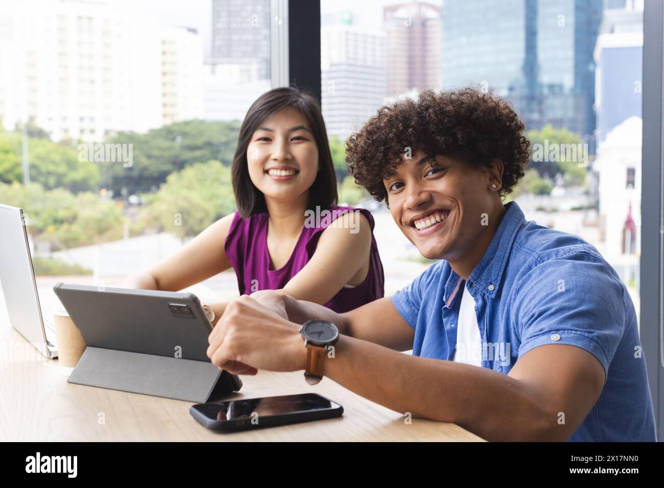 Diverse colleagues working together in a modern business office, smiling at camera Stock Photo