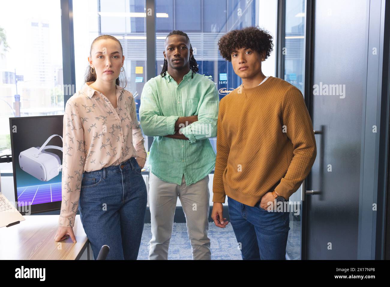 Diverse team standing in office, looking serious Stock Photo