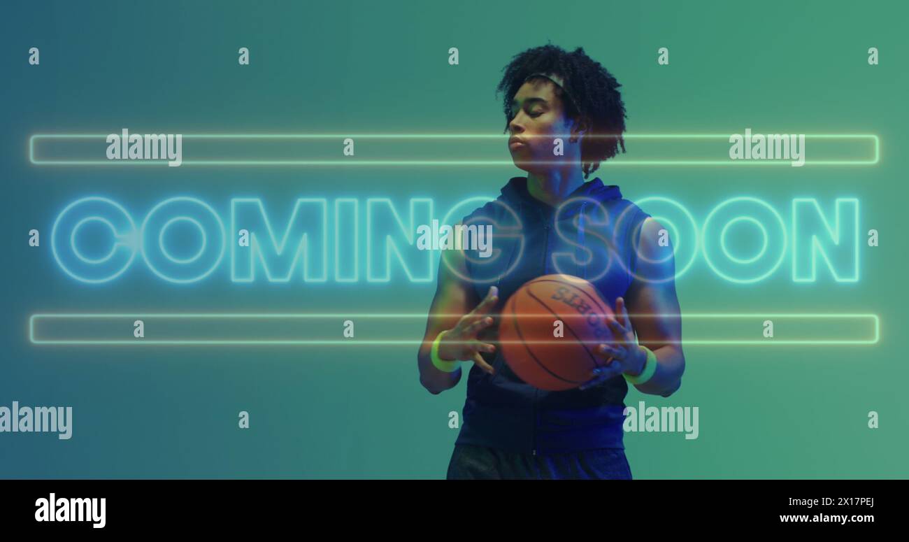 Image of coming soon text in neon over african american male basketball player holding ball Stock Photo