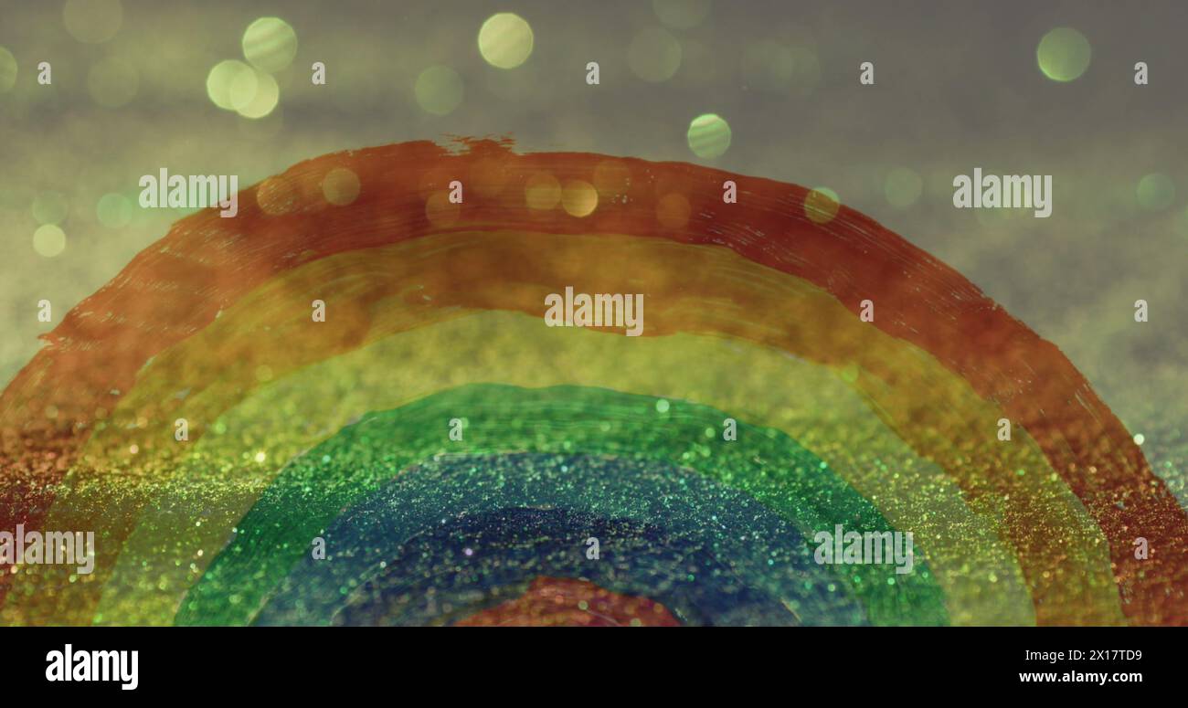 Image of hand painted rainbow over glowing sand falling in background Stock Photo