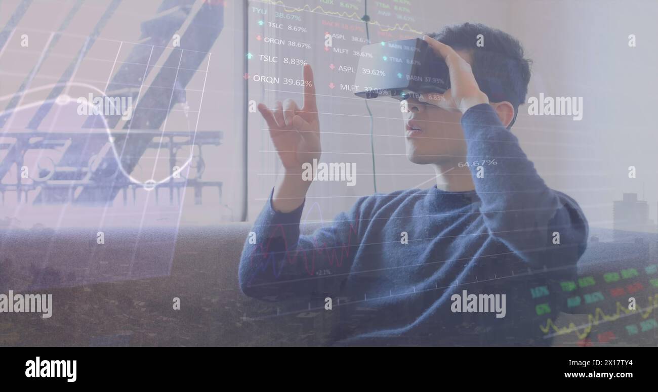 Image of financial data processing over biracial man using vr headset Stock Photo