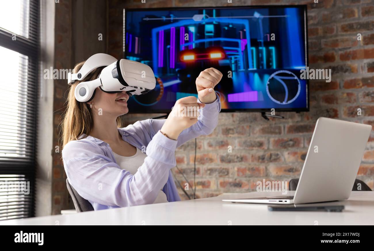 Caucasian young professional wearing VR headset, playing game in a modern business office Stock Photo