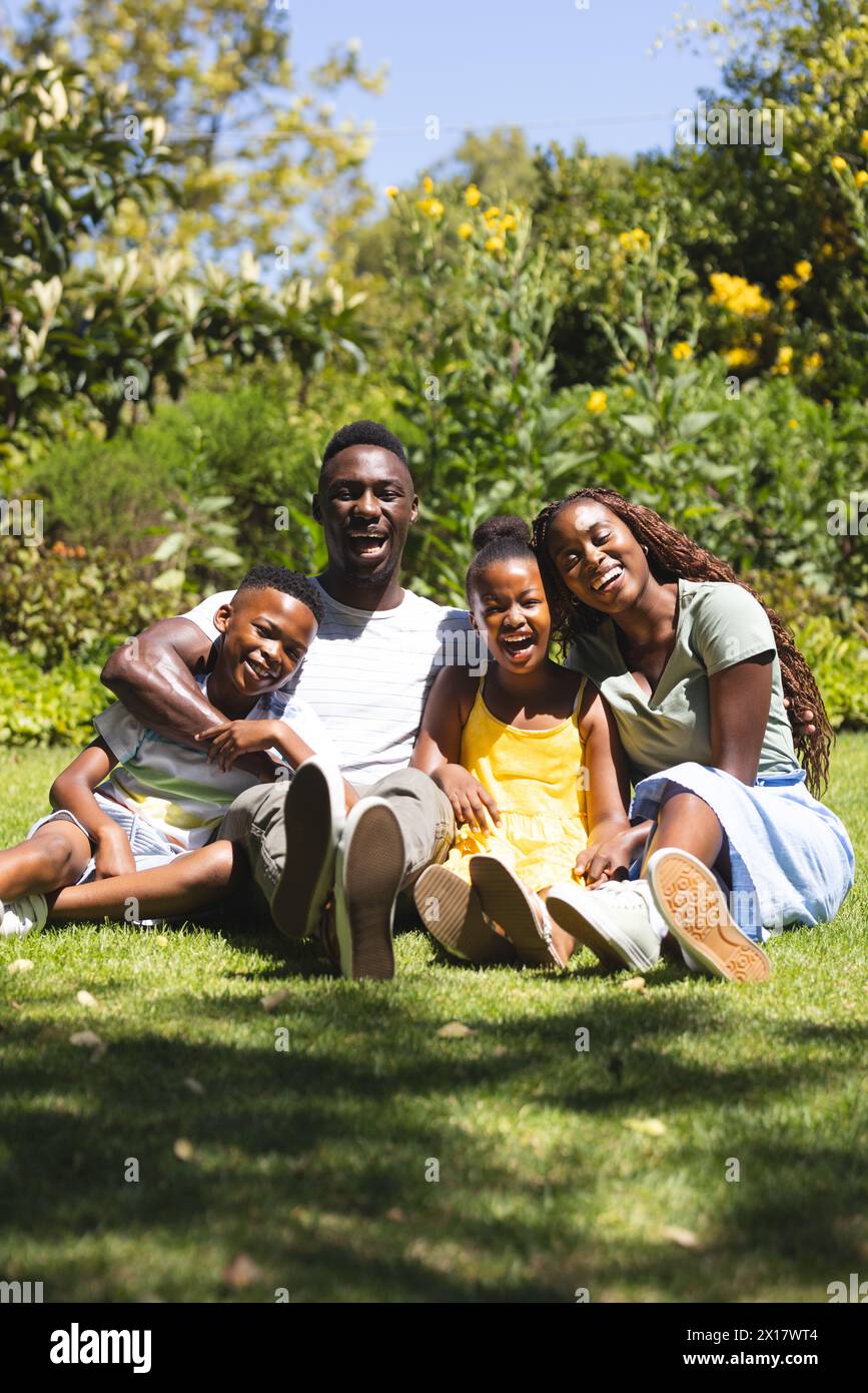 African American family sitting together, smiling in garden Stock Photo
