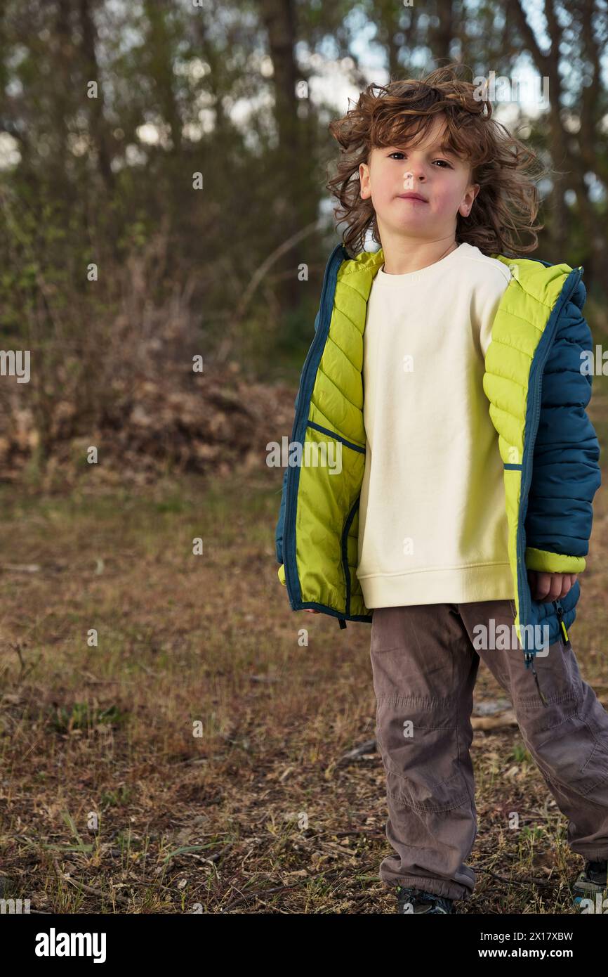 Cute girl in warm jacket standing in daylight Stock Photo - Alamy