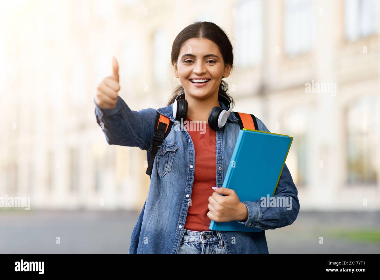 Indian student giving thumbs up on campus Stock Photo - Alamy