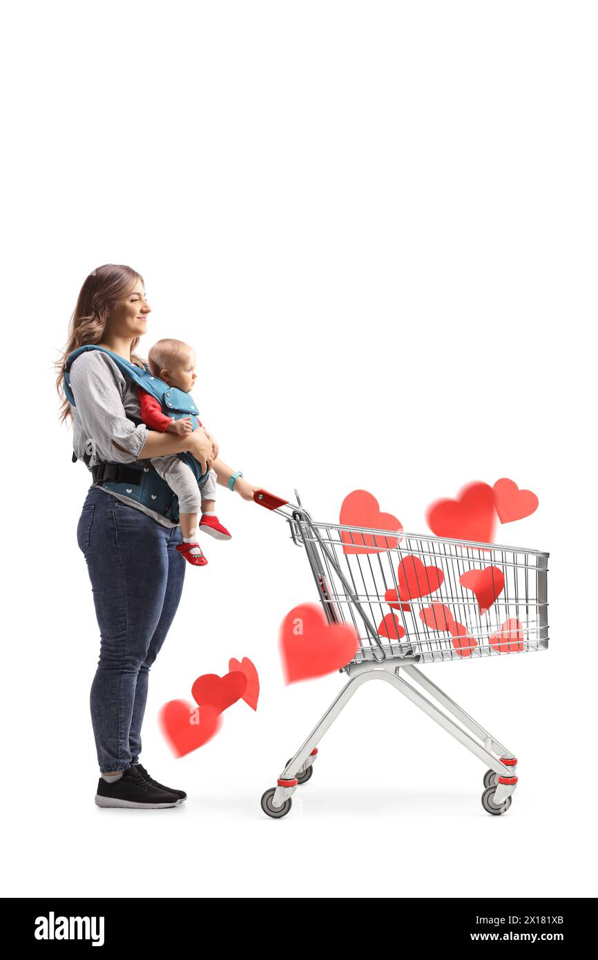 Full length shot of a mother with a baby in a carrier pushing a shopping cart full of red hearts isolated on white background Stock Photo