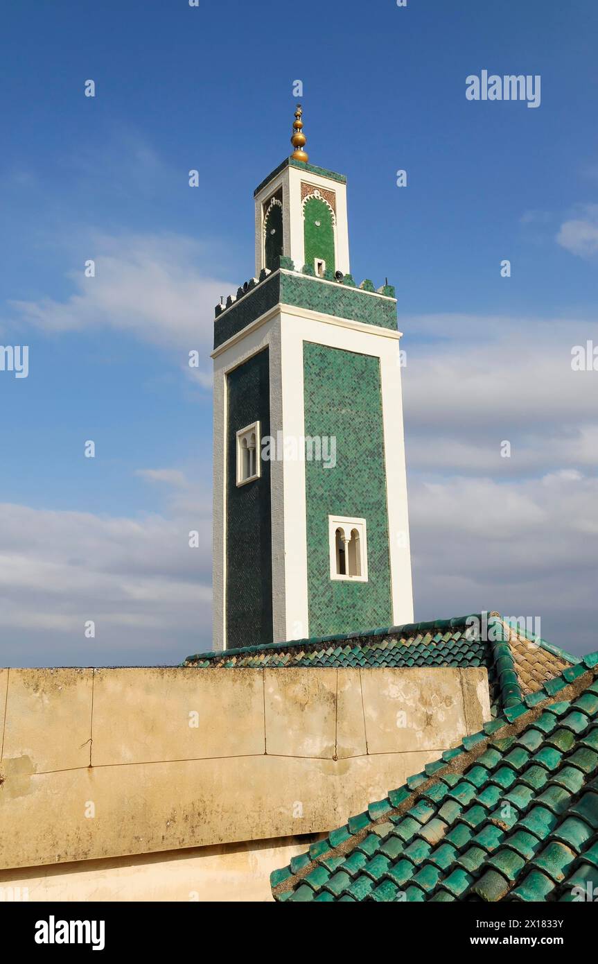 Minaret of the Medersa Bou Inania, Medina, UNESCO World Heritage Site, Meknes, Minaret rises into the blue sky with green roof tiles in the Stock Photo