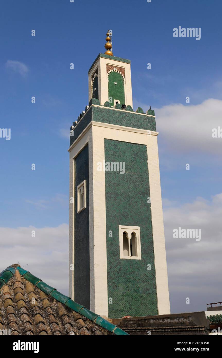 Minaret of the Medersa Bou Inania, Medina, UNESCO World Heritage Site, Meknes, Minaret against the blue sky with green panelling and golden Stock Photo