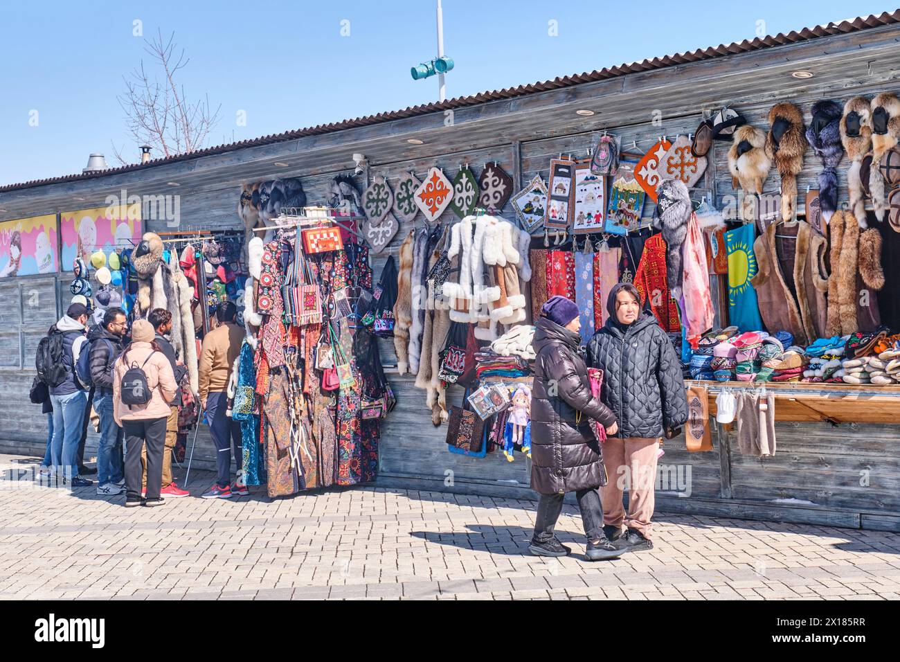 People in souvenir shop at outdoors local market. Kazakh colorful souvenirs and crafts. Stock Photo