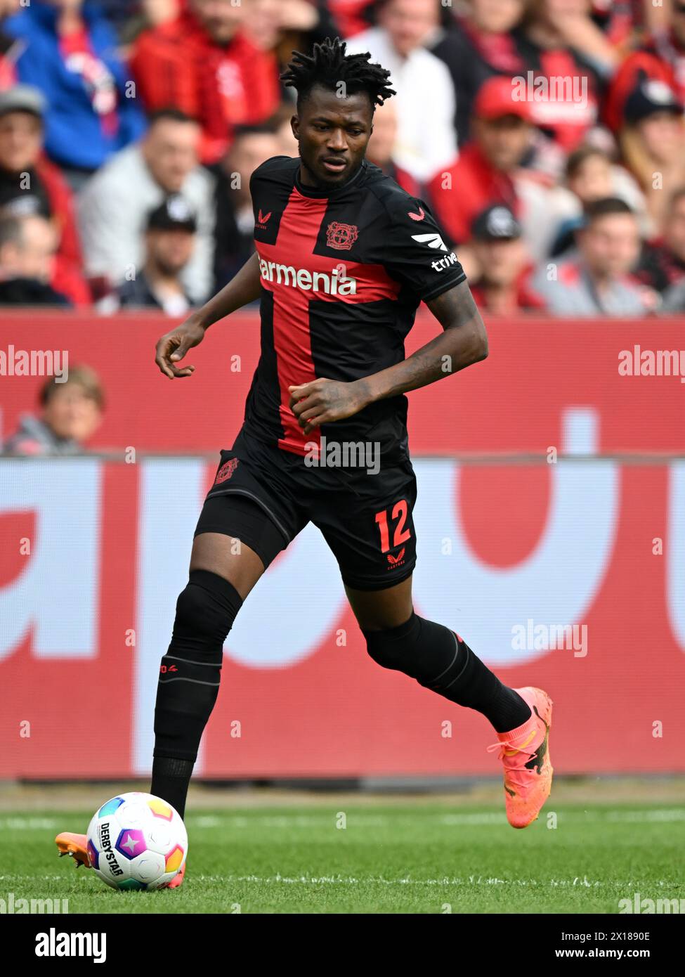 LEVERKUSEN - Edmond Tapsoba of Bayer 04 Leverkusen during the Bundesliga match between Bayer 04 Leverkusen and Werder Bremen at the Bay Arena on April 14, 2024 in Leverkusen, Germany. ANP | Hollandse Hoogte | GERRIT VAN COLOGNE Stock Photo