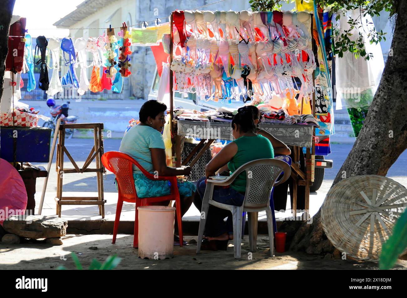 Leon Nicaragua, Market stall with clothes and seated people in the shade of a tree, Nicaragua, Central America, Central America Stock Photo