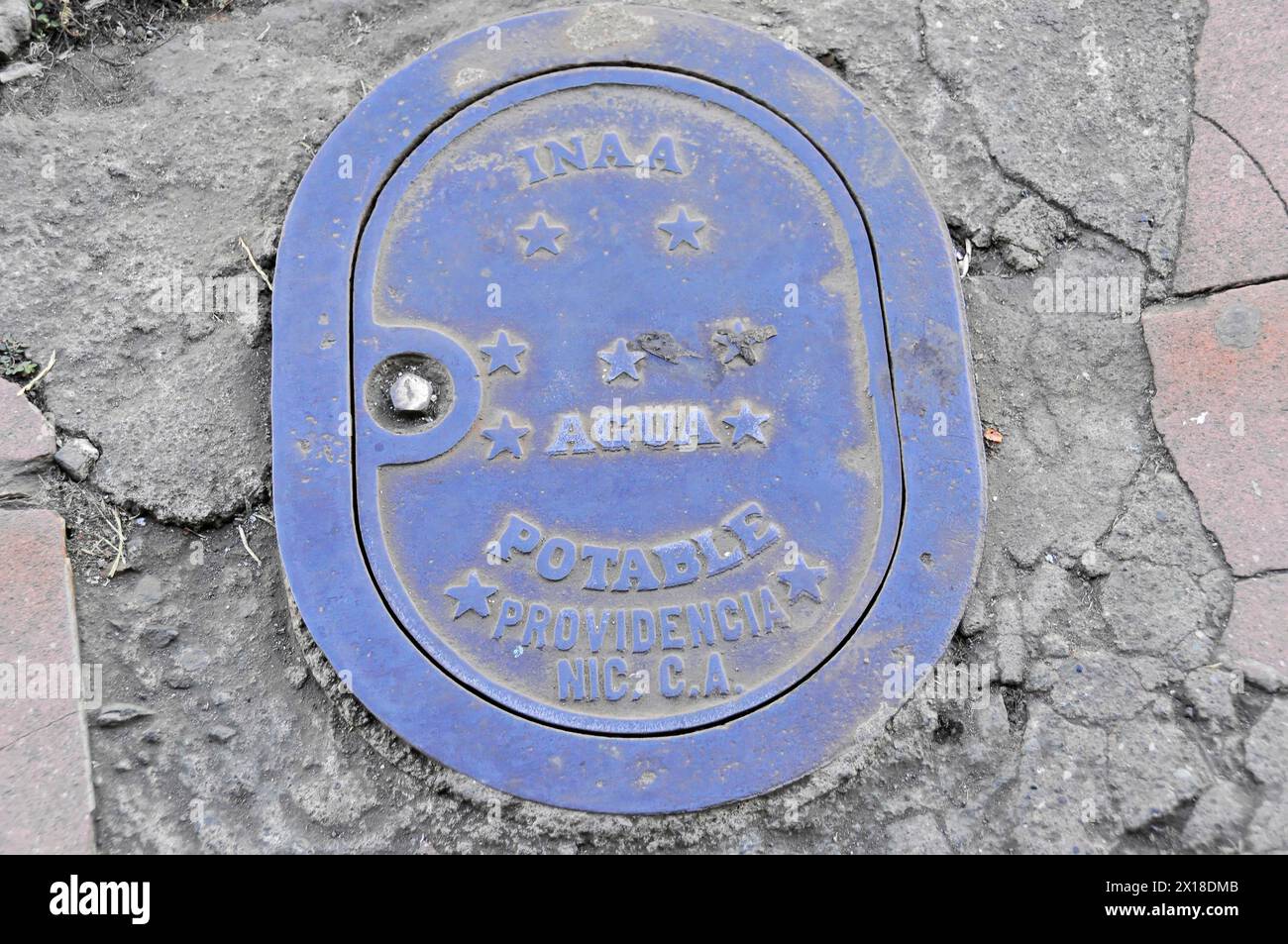 Leon, Nicaragua, A blue manhole cover with stars and the inscription 'AGUA POTABLE' on paving stone, Central America, Central America - Stock Photo