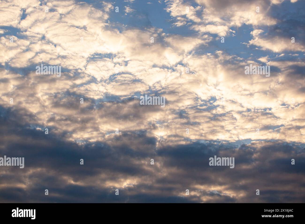 Blue sky background with small golden clouds. Horizontal. Texture Stock Photo