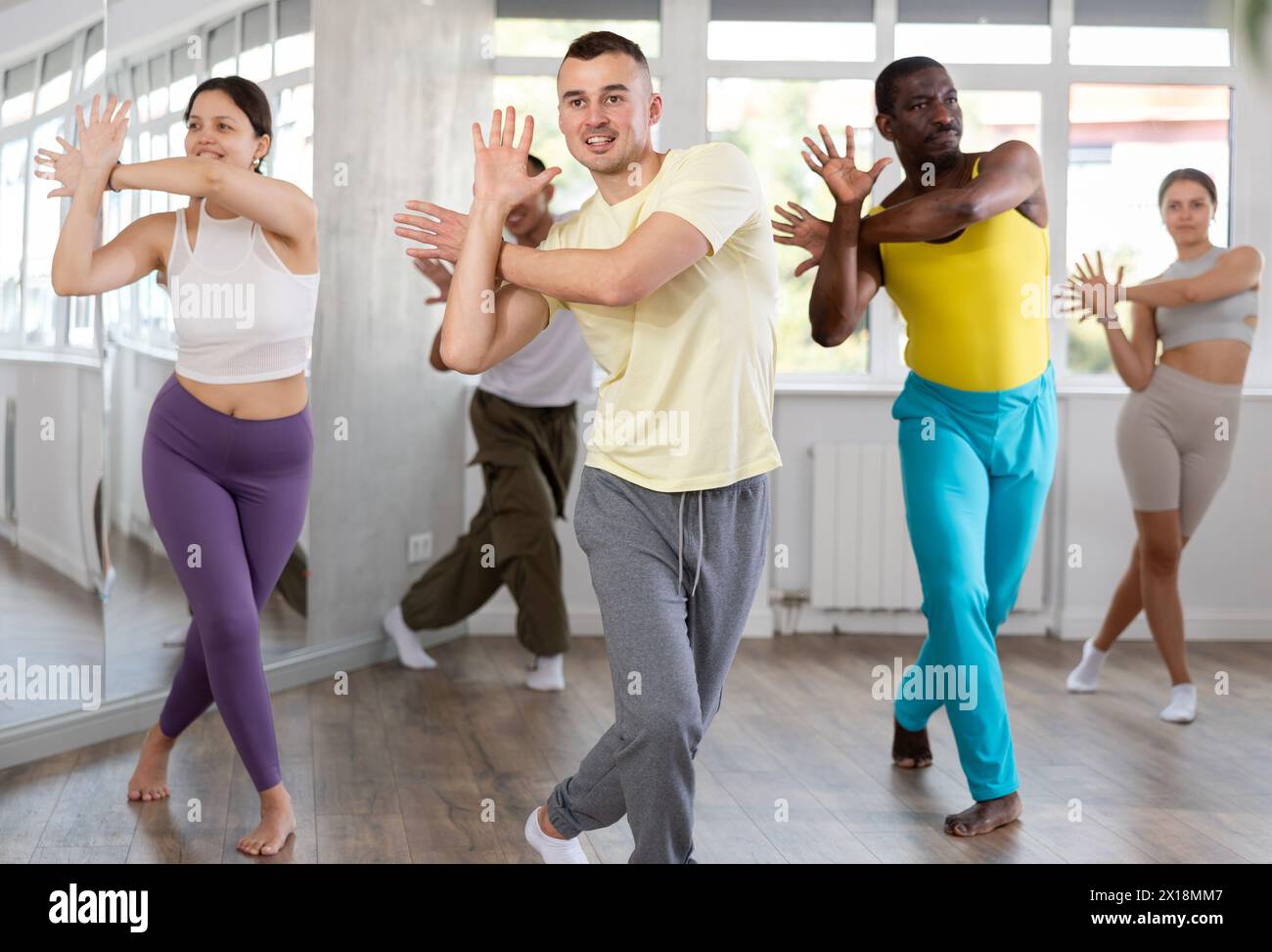 Young instructor leading zumba class for multiethnic group Stock Photo
