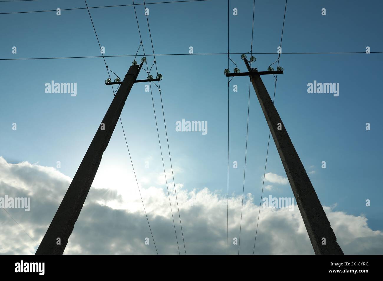 Telephone poles and wires against blue sky with clouds Stock Photo - Alamy